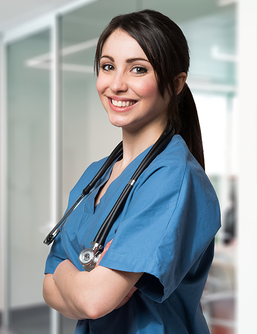 Smiling female nurse with stethoscope standing in hospital corridor

